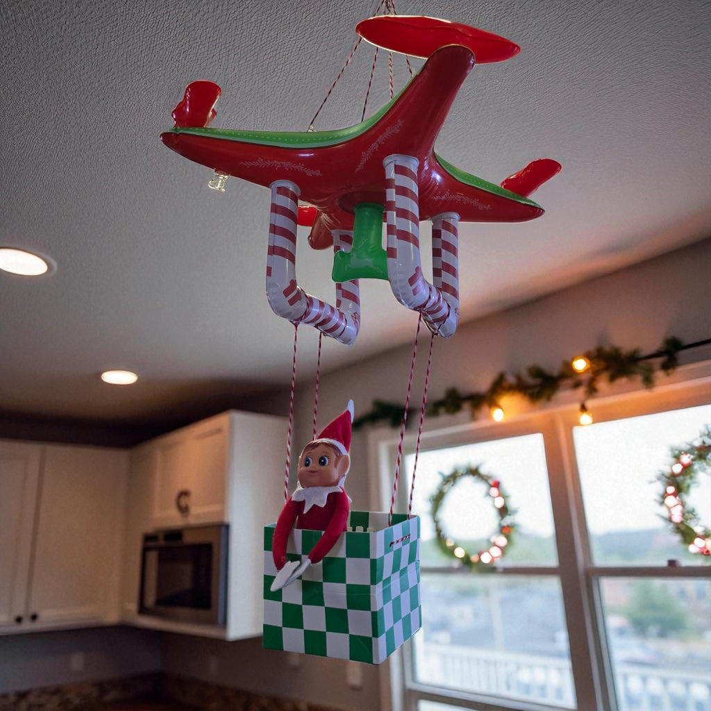 Inflatable toy drone hanging from the ceiling carrying a Christmas elf in a basket from the 24 day elf kit.