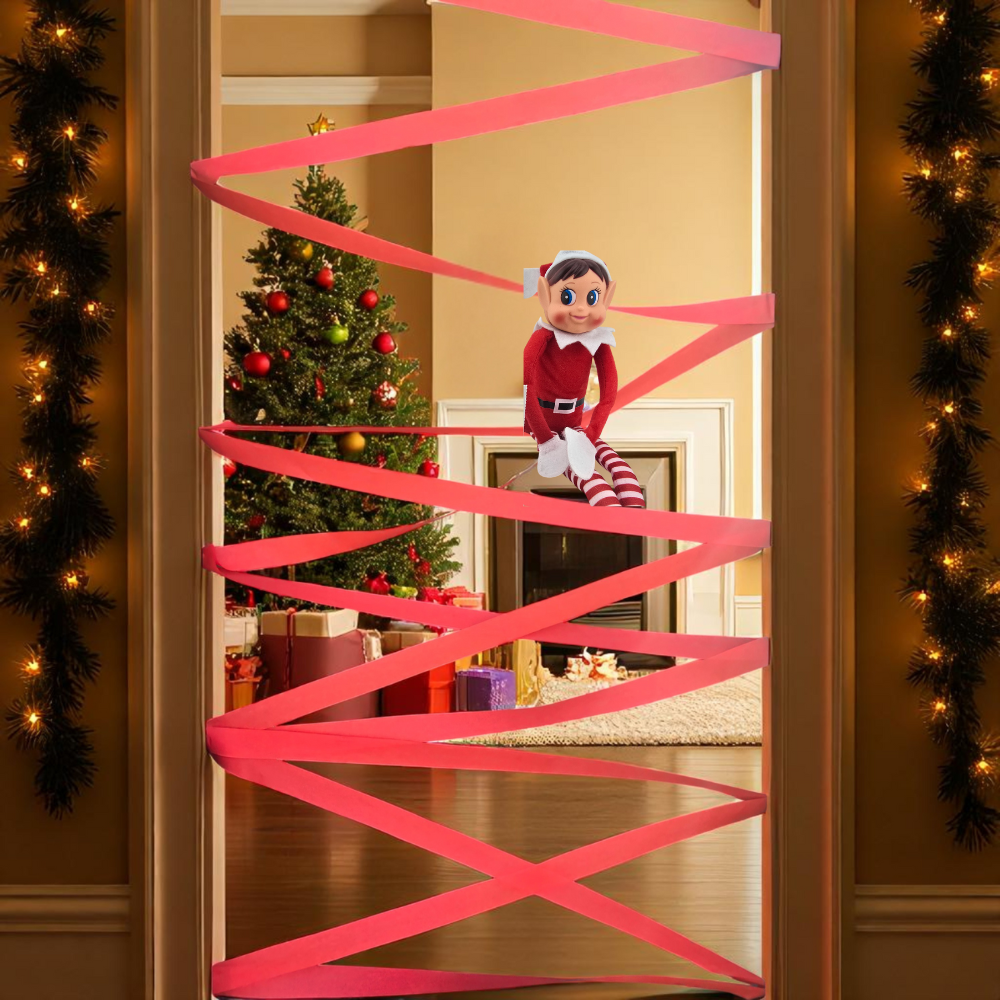 Christmas elf doll sitting on pink crepe paper streamers zigzagged across a doorway from the 24 day elf kit.